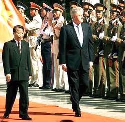 Năm 2000, Tổng Thống Clinton đến Hà Nội. Người đón là Trần Ðức Lương, Chủ Tịch Nước Bắc Cộng.